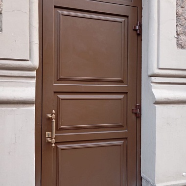 Двери в проёме здания, расположенного на улице рядом с Дворцовой площадью