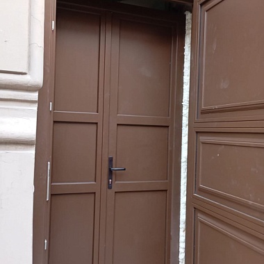 Двери в проёме здания, расположенного на улице рядом с Дворцовой площадью