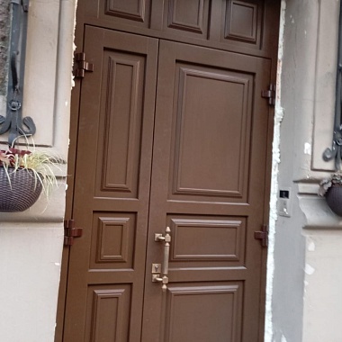 Двери в проёме здания, расположенного на улице рядом с Дворцовой площадью